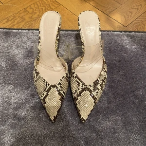 Klackskor - Ett par jättefina ormmönstrade klackskor från Zara i storlek 38. De har några bruna fläckar på det genomskinliga bandet, därav säljer jag de för nedsatt pris! Skriv privat för mer infor och bilder