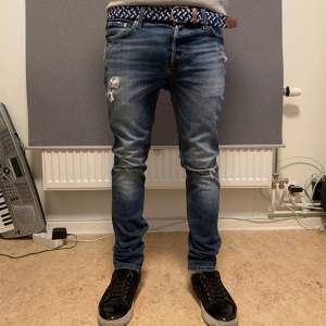 Säljer dessa asfeta mörkblåa Jack&Jones ripped jeans. Storleken är 29/32. Modellen är 178cm och väger 57kg. Nypris är 1159kr.