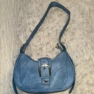 Jeansblå färgad handväska. Nyskick och justerbar. Bra kvalitet 