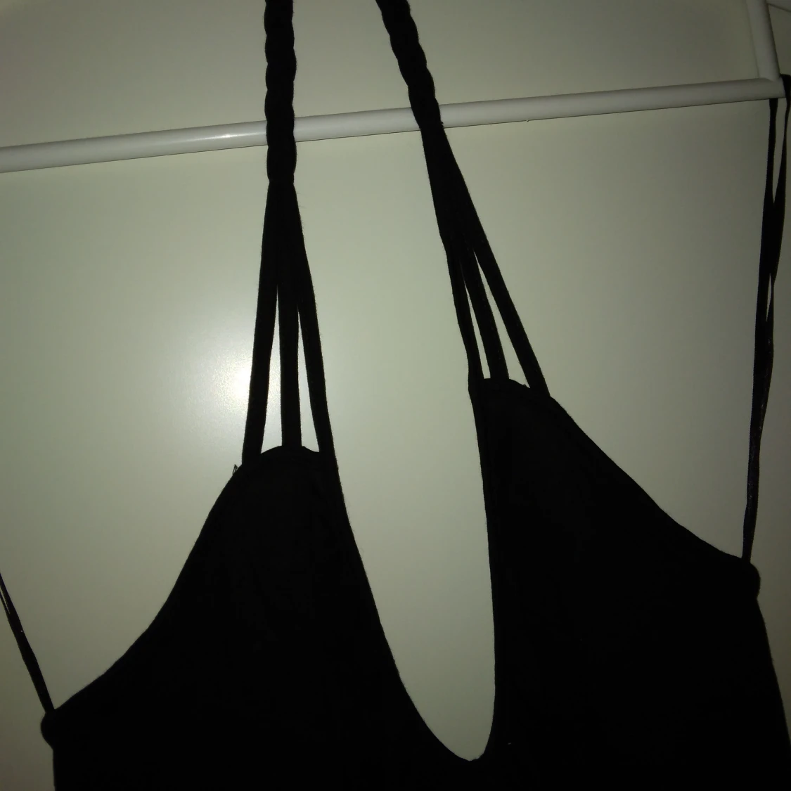 Svart oanvänd topp / linne. Flätat band i nacken, knyt nedtill. Strlk: XS-SMALL. Bomull  viskos. Felfri. - 2