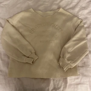 Collage tröja - Beige collage tröja. Rå mudd nedtill samt i halsringning. Tryck på magen. 