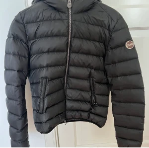 Colmar jacka st 42 - Denna jacka är svart med grå insida.Den har ett litet hål men mycket dun kvar i sig. Hade sparat den om de inte var för att den blivit för liten för mig🙁Nypris ligger på 4359kr. Köparen står för frakten((: