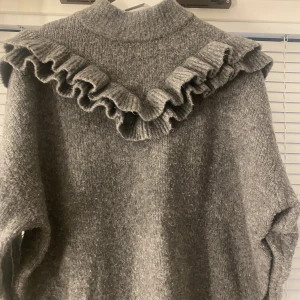 Stickad tröja med volang  - Säljer denna stickade tröja från Zara. Köpt här på Plick. Jättefin till höst!🤍 säljs pågrund av ingen användning. Fint skick!