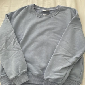 Ljusblå sweatshirt - Väldigt fin sweatshirt i bra skick. Den ser lite grå ut i kameran men den är fint ljusblå i verkligheten. Den har väldigt mjukt material. Säljs pga att den är för liten på mig. Har inga fläckar eller något sånt💗