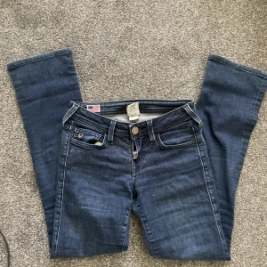 True religion lågmidjade jeans - Utsvängda, lågmidjade true religion jeans  Midjemått-32cm rakt över (ej runt)  Innerbenslängden- 72cm 