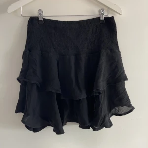 Svart volang kjol  - Svart volang kjol, använd fåtal gånger men så gott som ny, kjolen är i storlek s men skulle säga att den passar en m också 