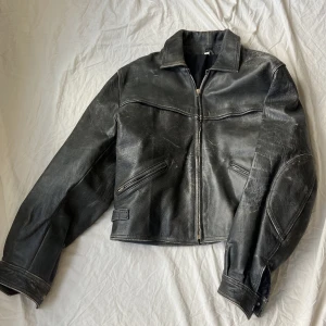 Vintage skinnjacka med slitningar - En så snygg vintage skinnjacka med najs slitningar!! Storlek S men passar både större och mindre beroende på vilken passform man vill ha :) Bulkig och med tydliga axlar!  Den sitter till höfterna på mig som är 165cm :) Pris går att diskutera!