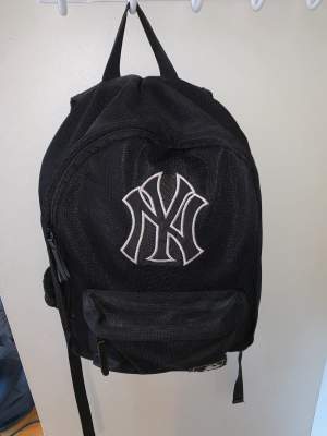 Svart liten baseball-ryggsäck ca 40 cm hög och 30 cm bred.