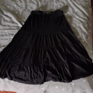 Svart lång kjol - Säljer denna fina kjolen för att jag aldrig använder den, Man kan dra ner så den blir lågmidjad utan att de ser konstigt ut. Elastiskt band vid midjan.