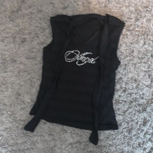 Linne - Linne med en pärltext och två snören. Kommer ej till användning. Vet inte vart den är ifrån och storlek står ej. Ungefär xs/s