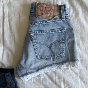 Levis 501 shorts  - Säljer ett par blå Levis 501 shorts. Storlek w28 med vit bomullsspets i nederkant. Äldre kvalité som jag älskar men de är tyvärr försmå för mig nu.