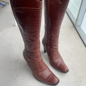 Läder stövlar - Så snygga läderstövlar i strl 39 med fyrkantig tå. Har några formade veck, men annars i toppskick. Fodrade med ett mjukt material intill som gör de väldigt bekväma. säljer då de tyvärr är lite för stora för mig. Skickar mått på förfrågan! 