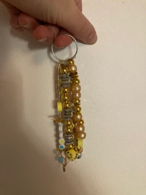 Guldig nyckelring ❤️‍🔥 - Jättefin guldig nyckelring med pärlor, glitter, smileys, text (party) & berlocker 🤩 6 stränger. 🤍