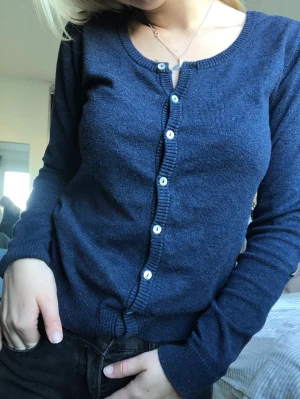 Kofta - Säljer favorit tröjan då den inte kommer till användning. Marinblå med stjärnor på armbågarna, pärlfärgade knappar. Original pris 400kr