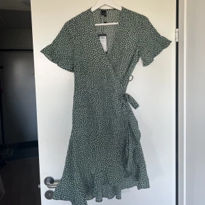 Grön prickig klänning från Vero Moda  - Oanvänd klänning från Vero Moda. Grön med vita prickar. Storlek S, Prislapp kvar 