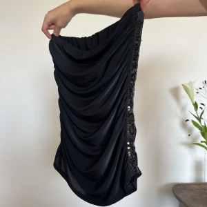 BANDEAU TOPP MED PALJETTER - Superfestligt bandeau topp med paljetter på sidan. Ett sånt vackert fall på toppen vilket gör den så unik. Helt oanvänd!  Hör av dig om du har fler frågor!💋