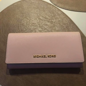 Michael kors plånbok - Michael kors plånbok. Nypris 1600 kr  säljes för 1000 kr. Certifikat följer med för intyg att allt är äkta.  Oanvänd  Säljer även en väska separat men köper man både väskan och plånboken blir det paketpris på 1800 kr