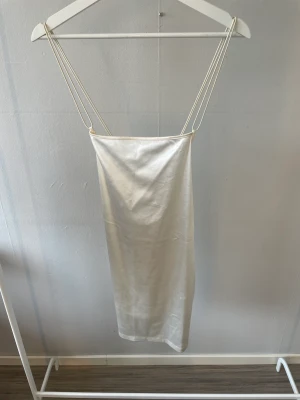 Figursydd klänning - Figursydd klänning från h&m. Aldrig använd bara testad. Prislappen är kvar. Fin snörning i ryggen! Guld, beige aktig i färgen