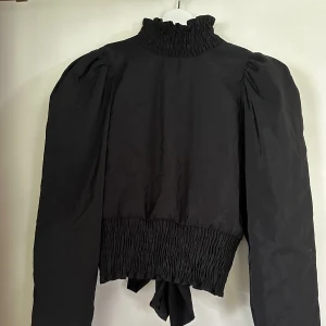 Tröja med öppen rygg. - Snygg tröja med öppen rygg och knytning. 