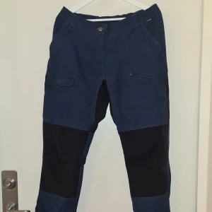 Fritidsbyxor  - Fritidsbyxor från CRW (Hööks) i superfin kvalitet med stretchpartier, hällor för bälte, fickor med dragkedja och ställbara benslut!  Perfekt för hemmafix, skogspromenader eller hundträning.  Strl 42