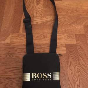 Äkta Hugo boss bag med guld text inga skador använt den några fåtal gånger Inge fel inget trasigt.