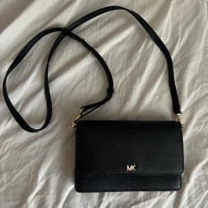 MK väska - Kuvertväska med justerbara band Använd fåtalet gånger🙌🏻 11x18cm, så den rymmer telefon och andra nödvändigheter😊 Har tyvärr inget äkthetsbevis då jag fick den i present men den är äkta🤍 Ny pris:2700kr