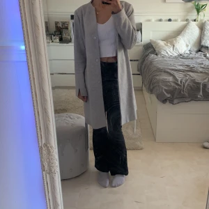 Stockh LM kappa grå - Grå längre kappa i välskött skick. Perfekt inför hösten då den håller värmen väldigt bra. Skulle säga att den passar både S och M