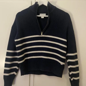 Stickad marinblå tröja - Mörkblå randig stickad tröja med krage och dragkedja. Storlek xs använd några gånger. Märke  Holly Whyte från Lindex. Köparen står för frakt😊