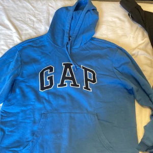 Blå Gap Hoodie (Storlek L) - Hoodin är i storlek large. Den är knappt använd. Gjord av bomull o polyester