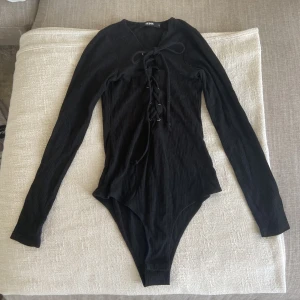 Svart Body - Ribbad body med Knyt, enkel att knäppa och aldrig använd. 