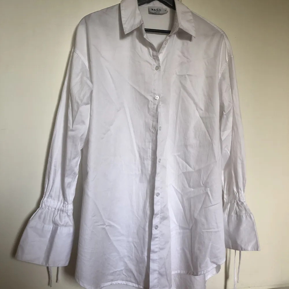 skjorta från Hanna schönbergs kollektion med NAKD, lång och har knytning i ärmarna . Skjortor.
