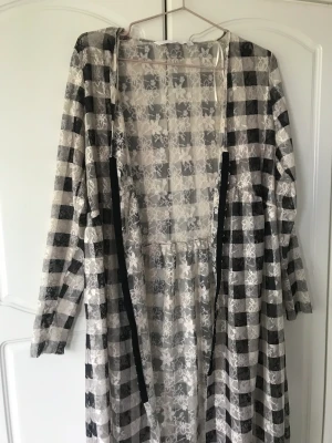 Lång cardigan - Lång, rutig cardigan i spetsmaterial. Tunn. Använd en gång. Lös passform men tight runt armarna. Hör av dig om du vill ha fler bilder 🙏