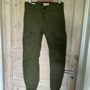Cargobyxor Jack&Jones  - Militärgröna Cargobyxor från jack&jones  Använda i mycket bra skick Nypris 699kr Skick 8/10