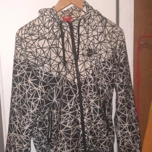 Vindjacka vit och svart - En vindjacka med svart och vita mönstrr.