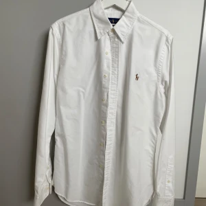 Ralph Lauren skjorta slim fit - Säljes då den inte passar mig. Mycket fint skick inget att anmärka på. Har legat i garderob så en tvätt sen är garderobslukten borta.