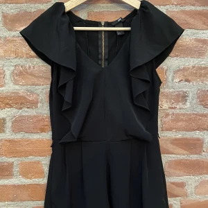 Byxdress  - Svart byxdress med volanger. Bra skick. 