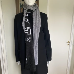 Halsduk  - Aldrig använd. Den är i en längre modell. Mått i cm: total längd 214, bredd 27. 