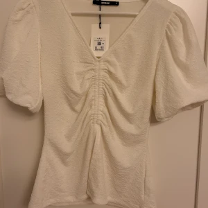 Vit topp  - Säljer denna gulliga vita topp frpn bikbok eftersom den inte kommer till användning. Toppen är helt oanvänd och har till och med lappen kvar, därav i nyskick🤍