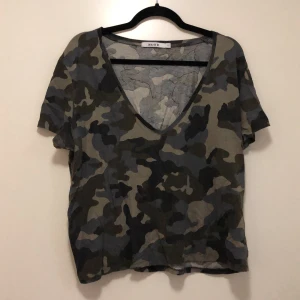 Camouflage croptop - En camouflauge top. Kort i modell och djupt v-ringad. Tänkt som en oversized S men passar större också. 
