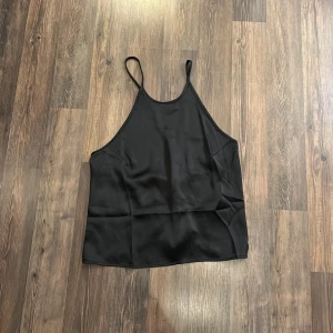 Svart topp - Svart topp med öppen rygg ifrån nakd i storlek 34