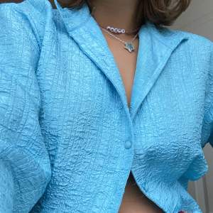 En blå skjorta som är i perfektlängd, slutar strax över busksnåren om man har lågmidjat, så fin färg och perfekt till både vardags eller en utgång! Skriv för fler bilder, pris är diskuterbart