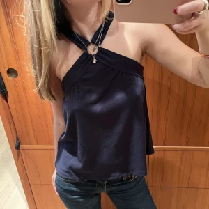 Mörkblå topp - Mörkblå topp med ring som detalj. Storlek S.