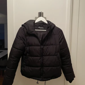 Vinterjacka  - Jacka med luva, 2 fickor, muddar i ärmarna och dragsko nedre kanten.