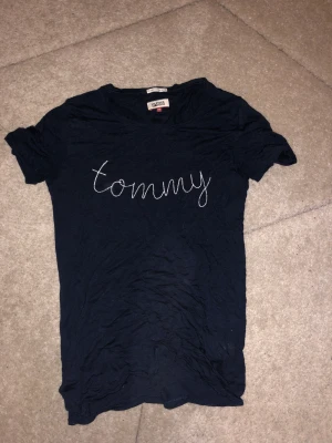 Marinblå tröja - Marinblå t-shirt ifrån Tommy Hilfiger i storlek xs men skulle säga att den passar s/m också beroende på hur löst/tight man vill att den ska sitta ☺️ Bra skick, luftigt och mjukt material.
