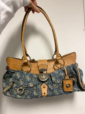 Vintage Guess väska  - Ursnygg äkta vintage denim GUESS väska!! Knappt använd, bara hängt på väggen och kommer tyvärr inte till användning därav säljer jag den. Pm för fler bilder, den ligger ute på flera sidor så först till kvarn gäller. 
