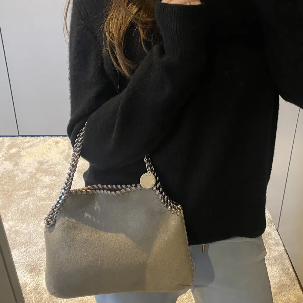 En sååå fin Stella McCartney Väska i grå färg med silver kedjor. Köptes helt ny på Miinto 2021💕 Bredd: 28 cm och höjd: 21 cm Den är i super bra skick🩷 (Nypris 6000kr - säkert lite mer nu)❄️. Väskor.