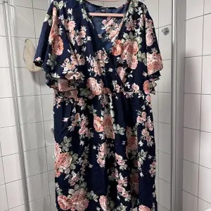 Blommig klänning marinblå  Ok skick  Storlek 52-54  Polyester 