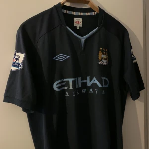 Manchester City-matchtröja - Manchester city bortaställ 2012. Etihad-trycket på magen är lite slitet men i övrigt väldigt fint skick. Storlek Large.