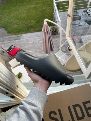Yeezy Slide Granite - Hej!  Yeezy Slide Granite Storlek: 44.5 (passar 42-43) Skick: Helt nya Box och kvitto finns, köpta på Adidas  1199kr, jag bjuder på spårbar frakt via PostNord.
