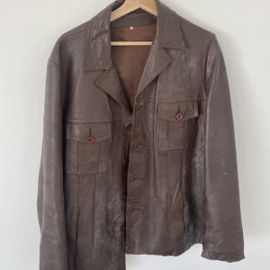 Brun skinnjacka - Mörkbrun skinnjacka köpt second hand för 700kr. Lite sliten. Ganska oversize jag är 180 och den är oversize på mig.
